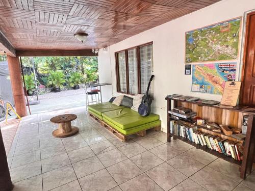 福尔图纳Rio Danta Hostel的客厅配有绿色沙发和桌子