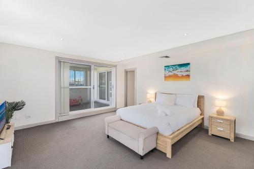安特兰斯Ocean Parade - Penthouse - Ocean Views的一间卧室配有一张床、一把椅子和电视。