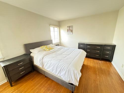 蒙特利公园市Cozy Home in Prime Location的一间卧室配有一张大床和两张梳妆台。