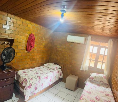 格拉瓦塔Casa de Campo em Gravatá super aconhegante的一间卧室配有两张单人床和一盏灯。