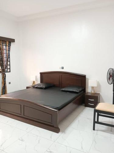 Abomey-CalaviMaison houefa service immobilier的一张大床,位于带桌子的白色客房内