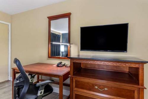 厄兰格ECONO LODGE的客房设有书桌、电视和椅子。