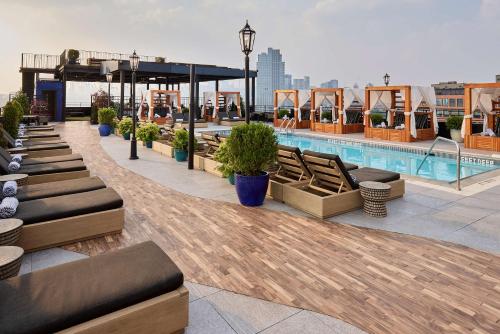 布鲁克林Arlo Williamsburg的一个带游泳池和躺椅的屋顶露台