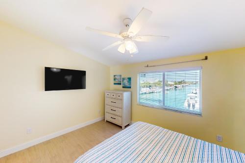 基克罗尼海滩KCB Canal Livin'的一间卧室配有吊扇和电视。