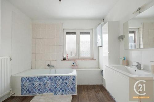 扎芬特姆appartement charmant à Zaventem的白色的浴室设有浴缸和水槽。