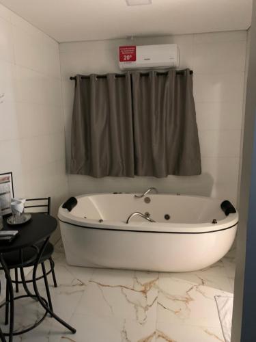 巴西利亚Hotel Oásis的带窗户的浴室内的白色浴缸