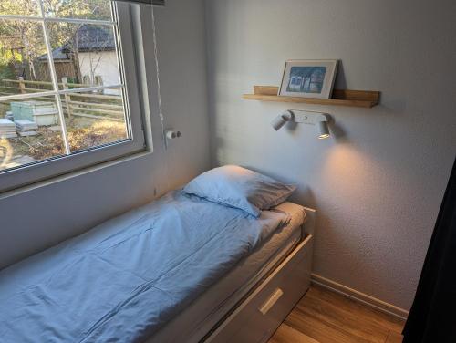 赫尔湾Mini-villa 200 m from Kämpinge beach的一间小卧室,卧室的床铺位于窗户旁