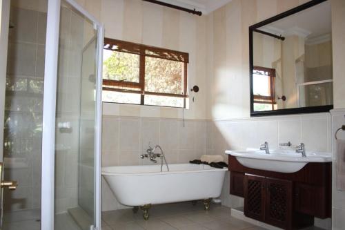 巴利托14 Zimbali Chalets的带浴缸、水槽和镜子的浴室