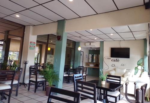 San Juan Bautista TuxtepecHotel Fragata的一间带桌椅的餐厅以及墙上的电视