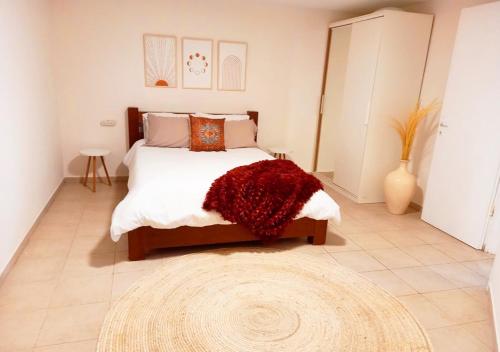 Gan H̱ayyimSpacious and Peaceful 2BD with a Garden & Parking的一间卧室配有一张红色地毯的大床