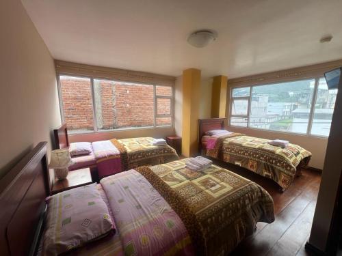 巴尼奥斯La Casa de Pia的带三张床和两扇窗户的房间