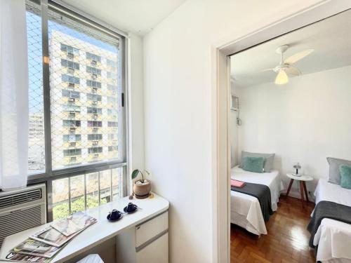 里约热内卢Ótima localização a 2 quadras da praia!Amei的一间卧室设有窗户、一张床和镜子