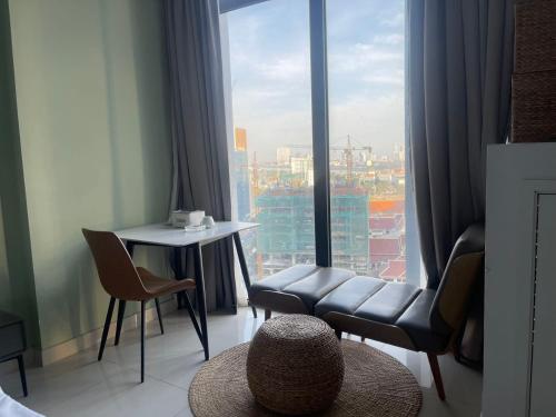 金边Zhong Xin Hotel的一间带椅子和桌子的房间以及大窗户