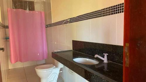 考卡亚Chácara Sitio Icaraí Caucaia-CE的一间带水槽和粉红色淋浴帘的浴室