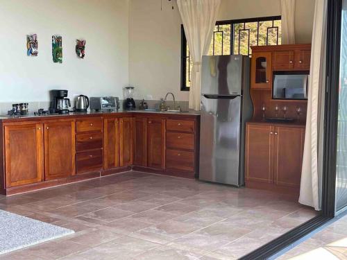 多米尼克Villa Del Mar 2 Spectacular ocean view!的厨房配有木制橱柜和不锈钢冰箱。