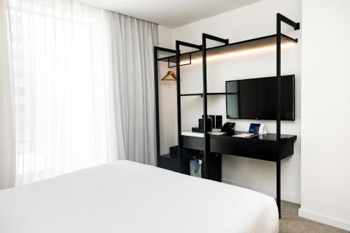 珀斯Quay Perth的一间卧室配有一张床和一张书桌及电视