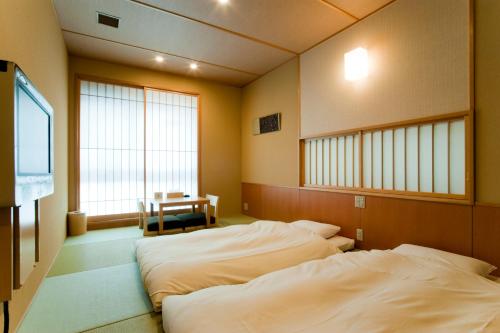东京御茶水酒店的配有电视和窗户的客房内的两张床