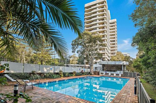 科夫斯港太平洋塔海滩度假酒店的一座高楼前的游泳池