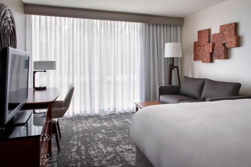 Park RidgeMarriott Park Ridge的酒店客房配有床、沙发和电视。