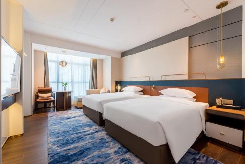 华东美豪雅致酒店广州白云机场花都文旅城店的酒店客房带两张床和一个客厅
