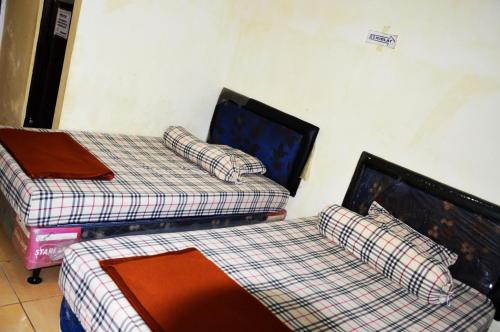 LampungCut Nyak Dien Guest House的配有两张床的客房内。