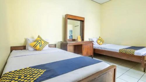 LampungCut Nyak Dien Guest House的带两张床和镜子的客房