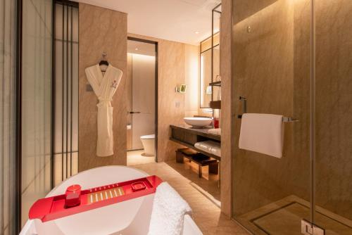 北京北京西南华邑酒店（免费客房升级）的浴室配有白色浴缸和淋浴