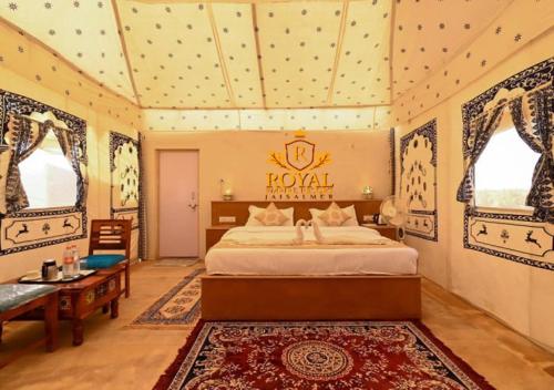 斋沙默尔Royal Empire Resort Jaisalmer的卧室配有床、桌子和窗户。