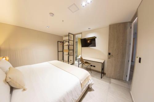 麦德林Sonata 44 Hotel Laureles的卧室配有白色的床和书桌