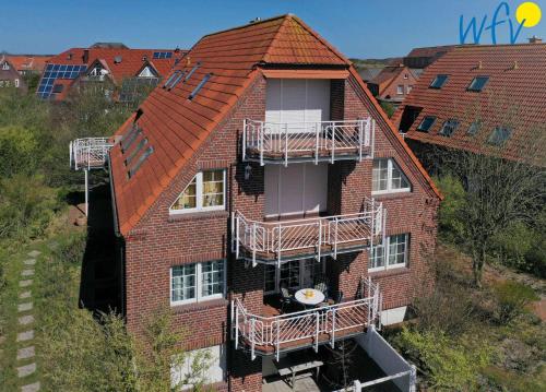 于斯德Luv und Lee - Ferienwohnung Juister Stuv的公寓大楼的一侧设有阳台。