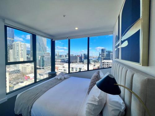 墨尔本Samma Flagstaff Luxury Apartments的一间带一张床的卧室,享有城市美景