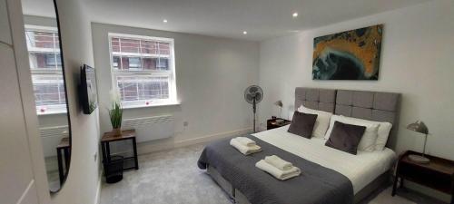 坎伯利Modern 1 Bedroom Apartment Town Centre Camberley的一间卧室配有一张床,上面有两条毛巾