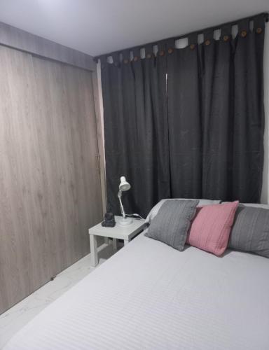 麦德林Hostel Campoamor的一间卧室配有一张床和一张带台灯的桌子