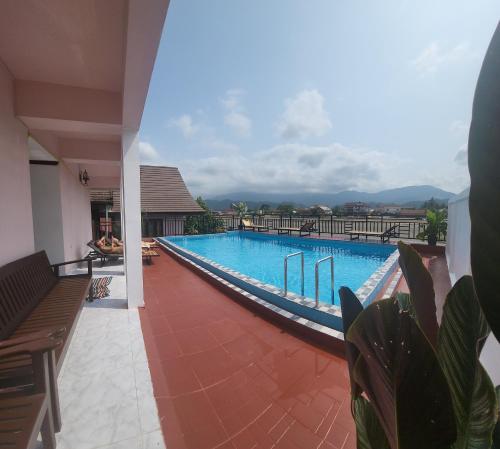 万荣Vangvieng Sisavang Mountain View Hotel的大楼内带长椅的大型游泳池