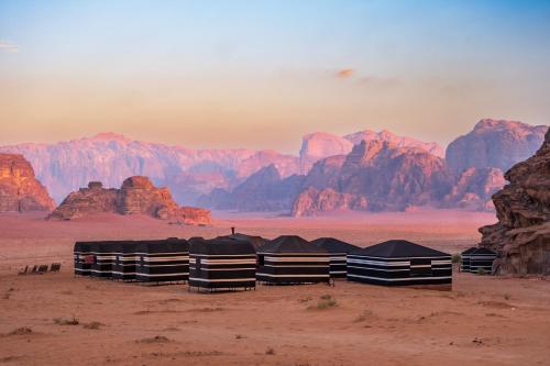 瓦迪拉姆Wadi Rum Fire Camp的一群在沙漠中与山 ⁇ 交织的帐篷