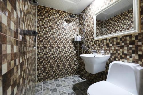 首尔城际首尔酒店 的一间带水槽、卫生间和镜子的浴室