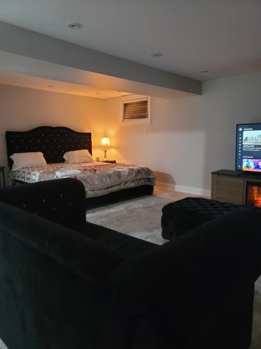 布兰普顿Langston Beautiful Home的一间卧室配有一张床和一台平面电视