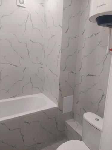 科克舍套Квартира посуточно的白色的浴室设有卫生间和浴缸。