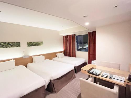 大阪京阪奇尔纳什大酒店的酒店客房设有三张床和一张书桌