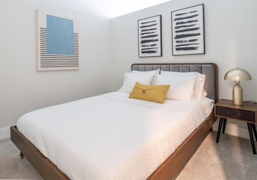 辛辛那提Cozysuites l Gorgeous 1BR in Downtown Cincinnati的一间卧室配有一张带白色床单和一张桌子的床。