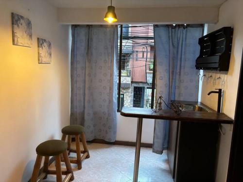 贝约Apartamento en Bello Medellín的厨房配有柜台,窗户前设有两个凳子