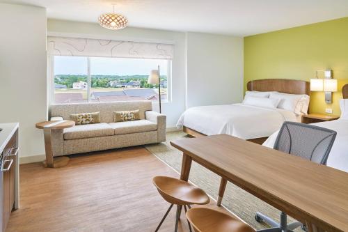 西得梅因西德梅茵源宿酒店的酒店客房配有床、沙发和桌子。