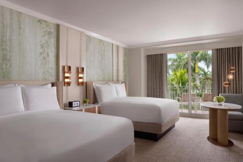 那不勒斯The Ritz-Carlton Naples, Tiburon的酒店客房设有两张床和窗户。