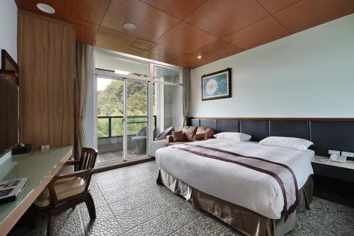 鹿谷乡溪头夏缇饭店的配有一张床、一张书桌和一扇窗户的酒店客房