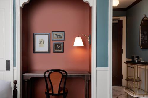 底特律Hotel David Whitney, Autograph Collection的走廊上设有桌椅和台灯