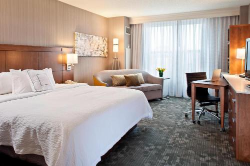 普韦布洛普韦布洛万豪万怡酒店的酒店客房设有一张大床和一张书桌。