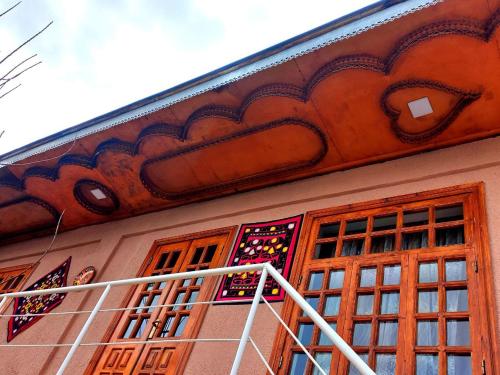 撒马尔罕Istirohat guest house的一座带窗户的建筑和一个带屋顶的阳台