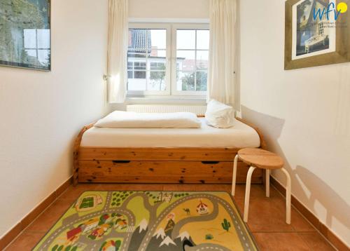 于斯德Luv und Lee Ferienwohnung Pilsum的一间小卧室,配有床和窗户