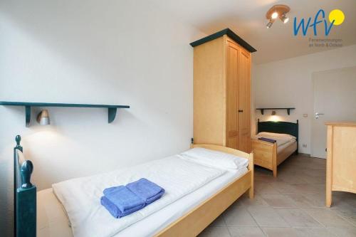 于斯德Luv und Lee Ferienwohnung Flügge的一间卧室配有一张带2条蓝色毛巾的床