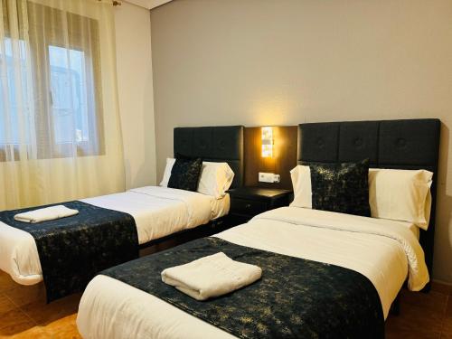 Barajas de MeloBallestar Hotel Bar & Grill的酒店客房设有两张床和窗户。